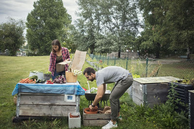 Couple working at table full of freshly harvested garden vegetables