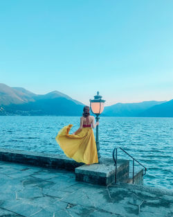 Man in boat on sea against blue sky