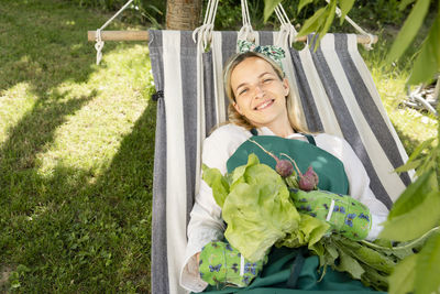 Portrait of smiling young woman sitting on field