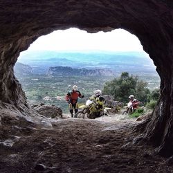 Tourists on rock formation against sky