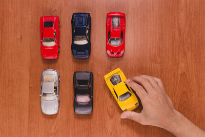 Cropped hand arranging toy cars on table