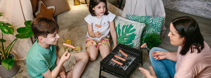 High angle view of mother and kids barbecuing at home