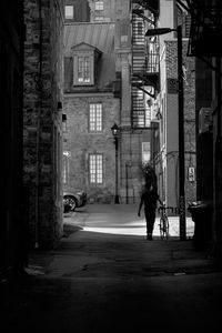 Man walking on road along buildings