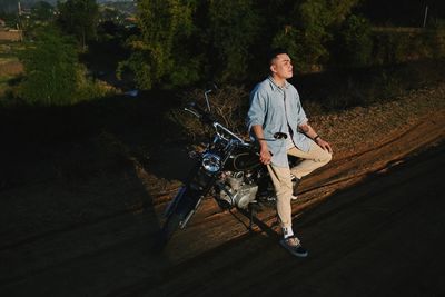 Portrait of man on motorcycle against trees