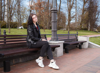 Woman sitting on bench in park