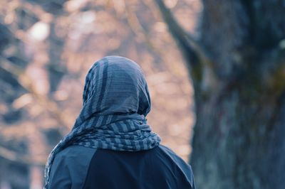 Rear view of person standing against trees during winter