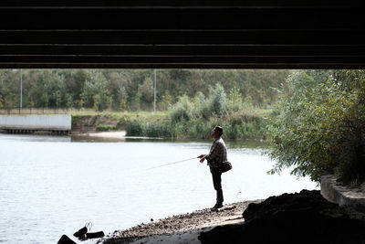 Full length of man standing on riverbank