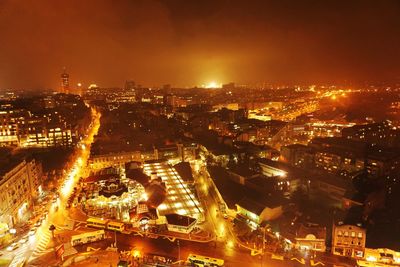 Illuminated cityscape against sky at night