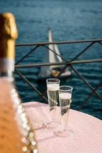 Close-up of champagne on table by sea