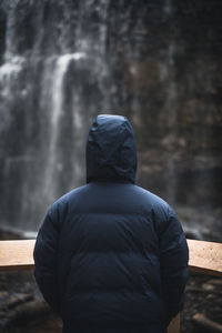 Rear view of man standing by water