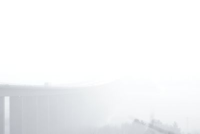 Snow covered landscape against sky during foggy weather