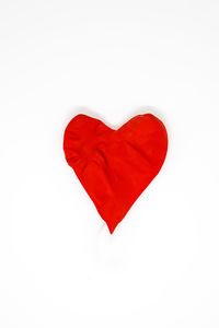 Close-up of red heart shape over white background