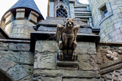 Low angle view of statue against historic building