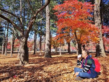 Woman sitting in park during autumn