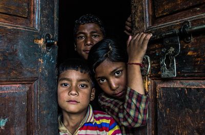 Portrait of girls and boys standing on door