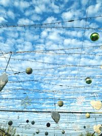 Low angle view of power lines against cloudy sky