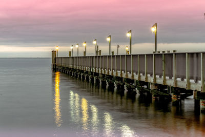 Pier over sea against sky during sunset