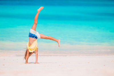 Midsection of woman with umbrella on beach