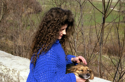 Woman with dog against retaining wall during winter