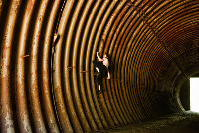 Full length of woman running on metal structure