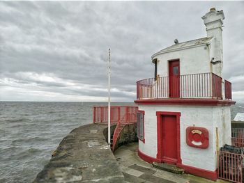 Lifeguard hut on beach against sky