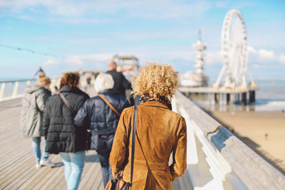 Rear view of tourists on pier