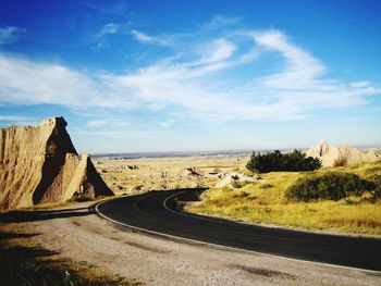 Scenic view of road by mountain against sky