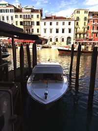 Boats moored on wooden post against sky