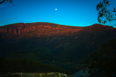 Scenic view of mountains against clear blue sky