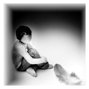 Rear view of boy sitting on table against white background