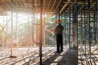 Rear view of a man standing against window