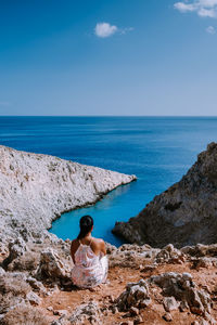 Rear view of man looking at sea against sky