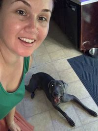 Portrait of woman with dog at home