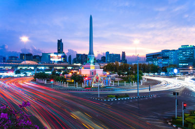 Light trails on street at victory monument at sunset