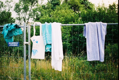 Clothes drying on fence at grassy field