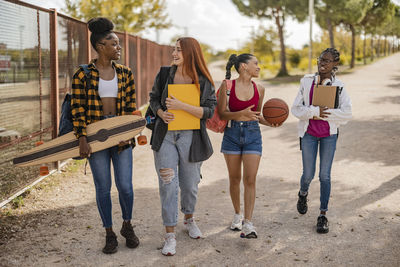 Young women walking together on road