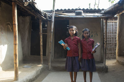 Portrait of young children in school uniform holding books