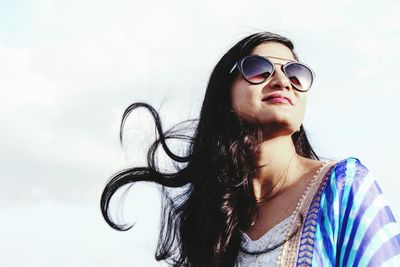 Portrait of young woman against sky