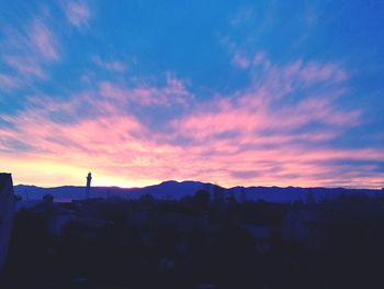 Silhouette buildings against sky during sunset