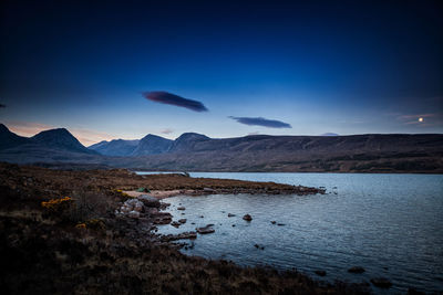 Scenic view of lake against sky at dusk