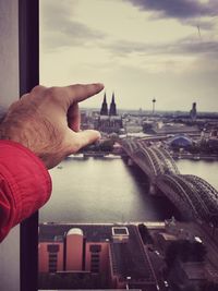 Cropped hand of man pointing towards cologne cathedral in city