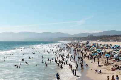 High angle view of people at beach against blue sky during sunny day