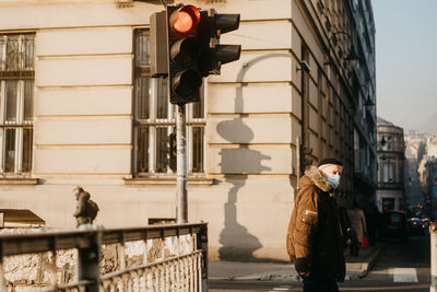 Woman with umbrella on street in city