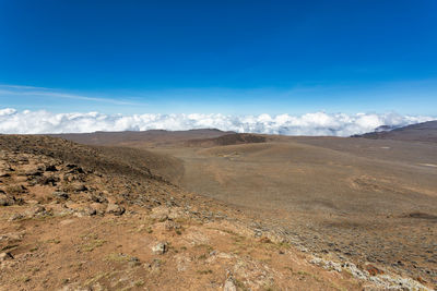 Scenic view of desert against blue sky