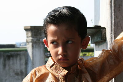 Close-up of sulking boy looking away outdoors