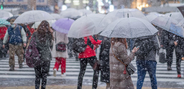 Crowd holding umbrellas during winter