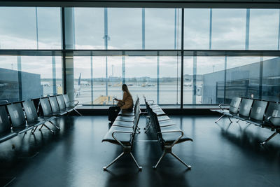 Rear view of woman sitting on chairs