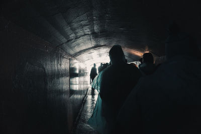 Rear view of silhouette people in tunnel