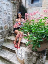 Full length of woman sitting on wall