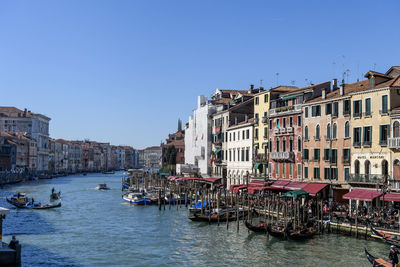 Boats in river against clear blue sky